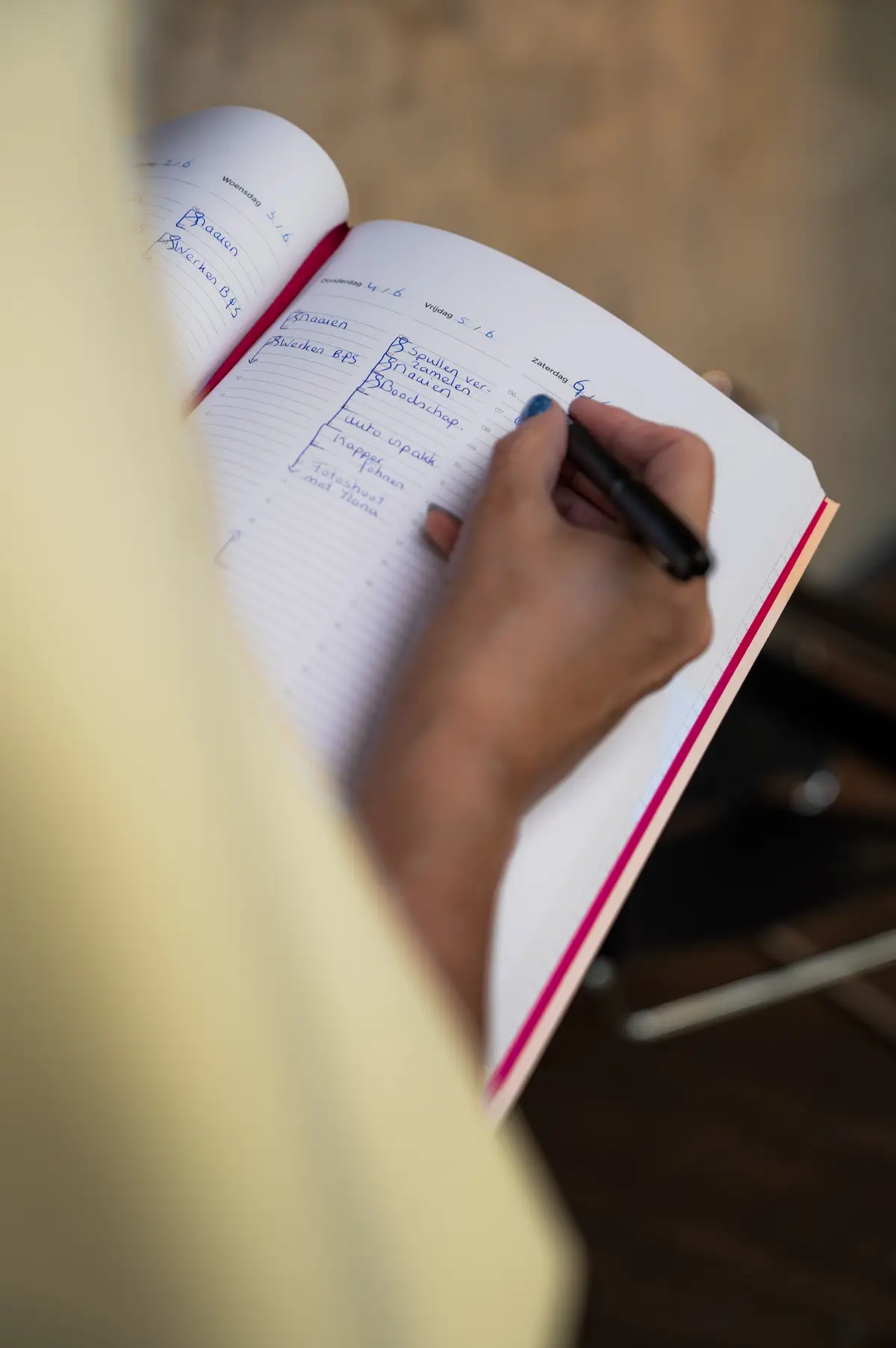 Desiree de Kort die wat in haar planner schrijft.